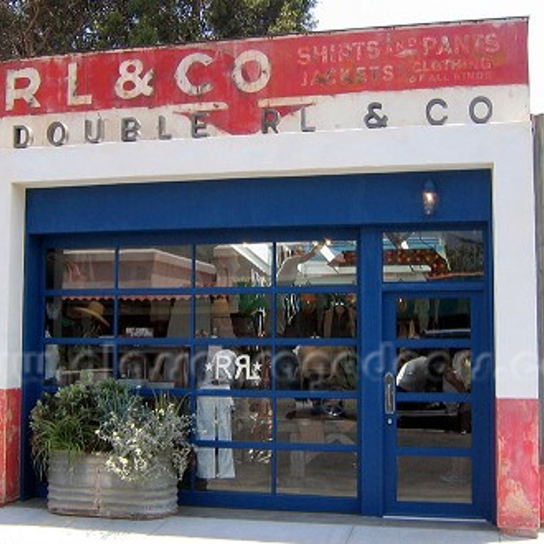 glass garage door storefront with entry door, showcasing a clothing store in Malibu, California.