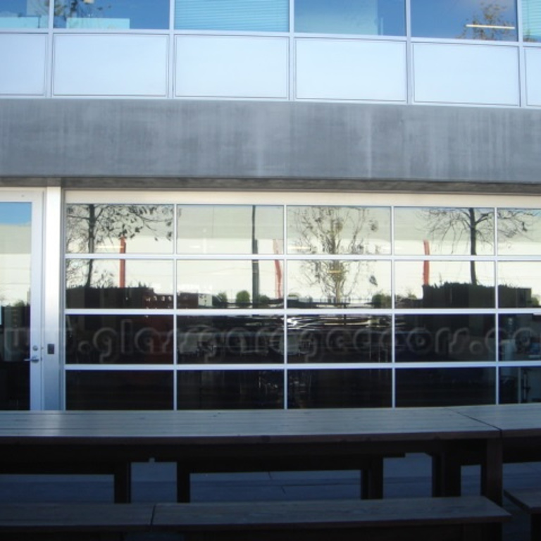 Custom glass garage doors installed in a Santa Monica commercial building, offering transparency and modern design.