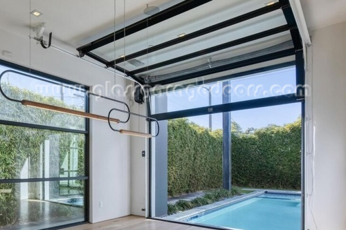 black frame and clear glass overhead door as divider for pool area