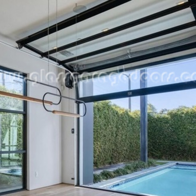 black frame and clear glass overhead door as divider for pool area