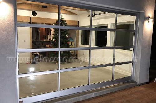 Insulated glass overhead door separating indoor and outdoor living spaces for modern home design