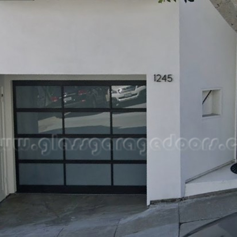 Modern black glass garage door with and single entry gate  white obscured glass on Montgomery Street in San Francisco, California 94133