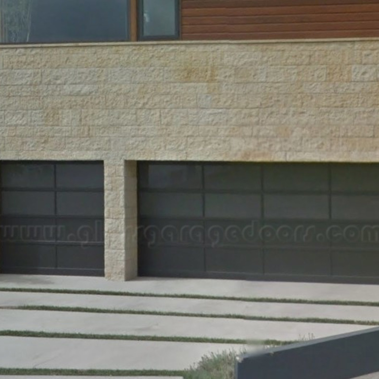 Modern black glass garage doors with Kynar finish and obscured glass in Pacific Palisades California Residence