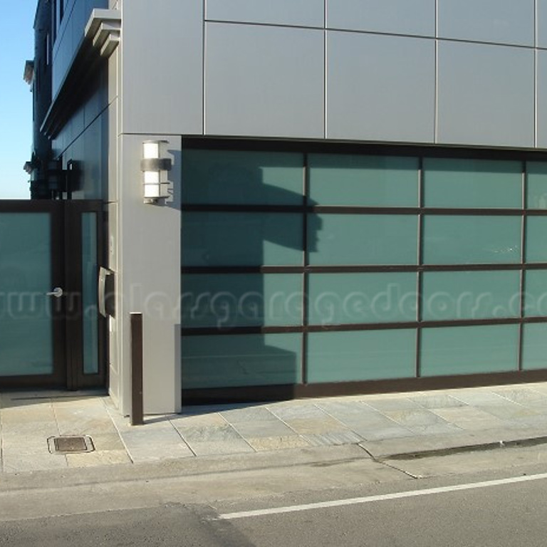 Brown Glass garage door and single entry door enhancing the exterior of a Newport Beach home