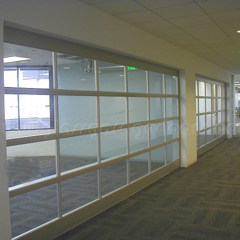 Modern glass garage door used as a space separator in an Irvine, CA office room, enhancing open-concept design and natural light