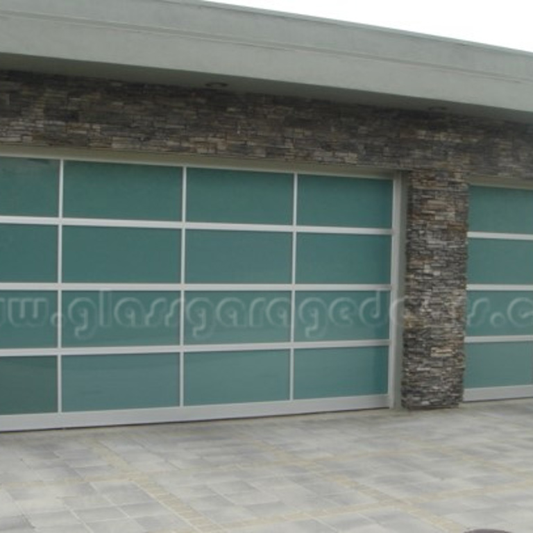 Two modern glass garage doors enhancing the exterior of a luxury Malibu home