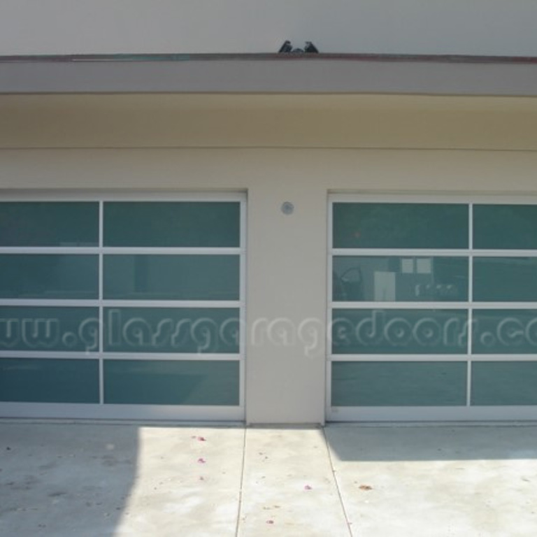 Beautiful glass garage doors featured in a coastal home in Dana Point, California, offering modern architecture and seamless design.